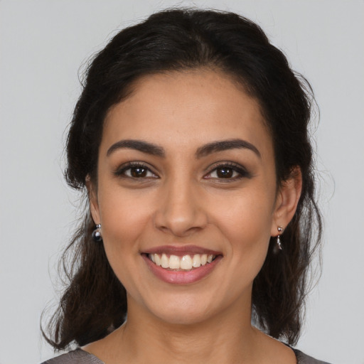 Joyful latino young-adult female with medium  brown hair and brown eyes