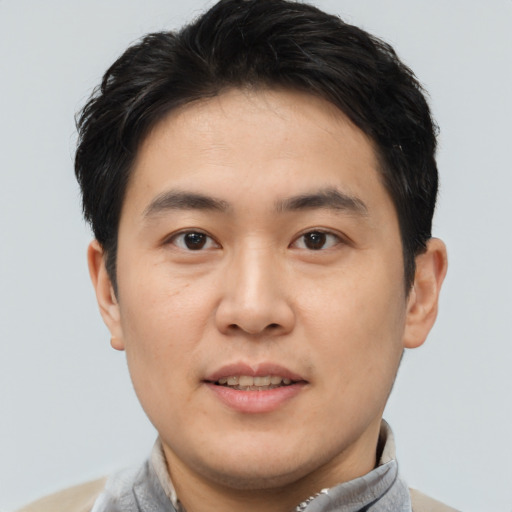 Joyful asian young-adult male with short  brown hair and brown eyes