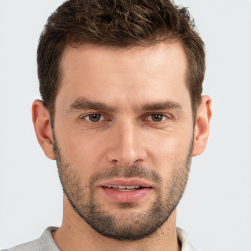 Joyful white young-adult male with short  brown hair and grey eyes