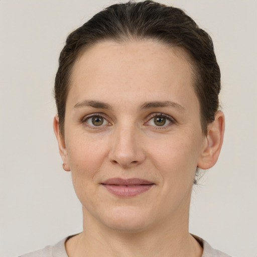 Joyful white young-adult female with short  brown hair and grey eyes