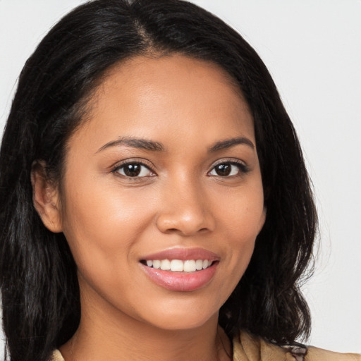 Joyful black young-adult female with long  brown hair and brown eyes