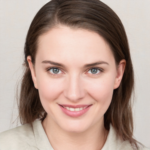 Joyful white young-adult female with medium  brown hair and grey eyes