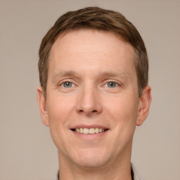 Joyful white adult male with short  brown hair and grey eyes