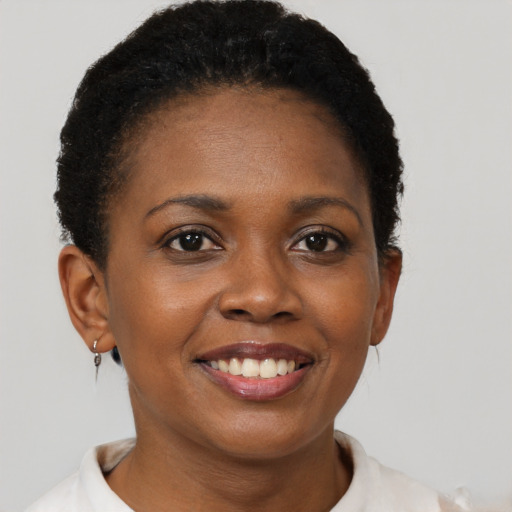 Joyful black young-adult female with short  brown hair and brown eyes