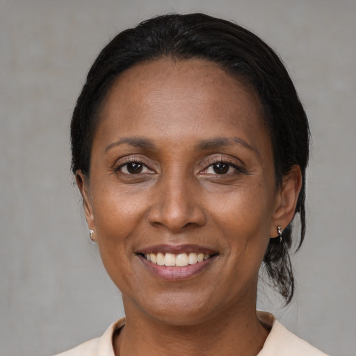 Joyful black adult female with medium  black hair and brown eyes