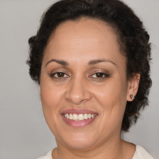 Joyful latino adult female with short  brown hair and brown eyes