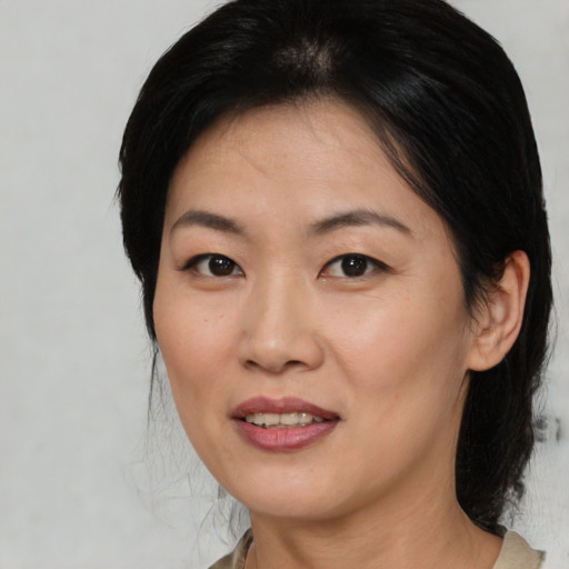Joyful asian adult female with medium  brown hair and brown eyes