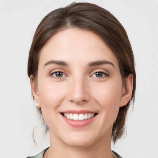 Joyful white young-adult female with medium  brown hair and grey eyes