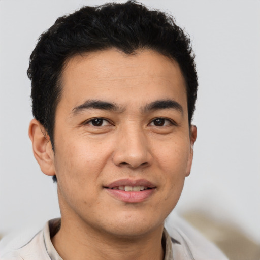 Joyful latino young-adult male with short  brown hair and brown eyes