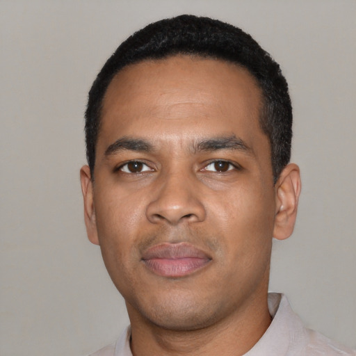 Joyful black young-adult male with short  black hair and brown eyes