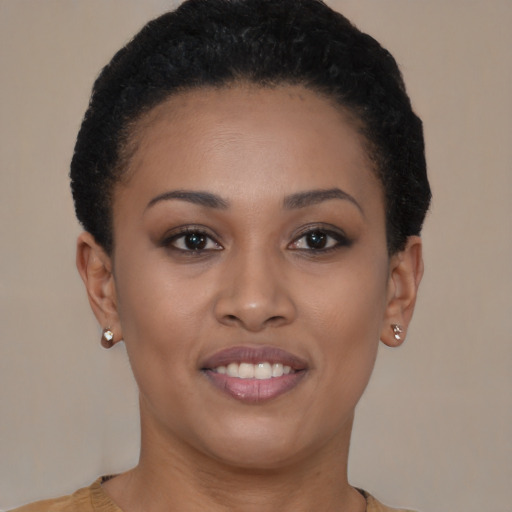 Joyful black young-adult female with short  black hair and brown eyes