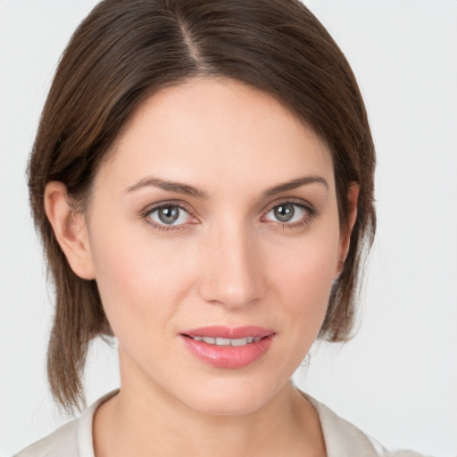 Joyful white young-adult female with medium  brown hair and grey eyes