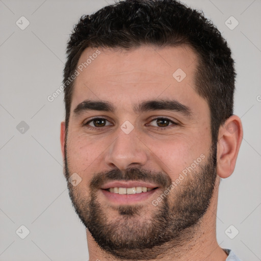 Joyful white young-adult male with short  black hair and brown eyes