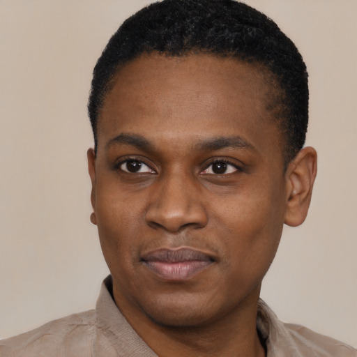 Joyful black young-adult male with short  black hair and brown eyes