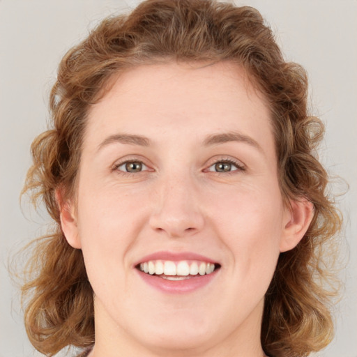 Joyful white young-adult female with medium  brown hair and green eyes