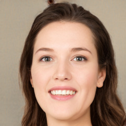 Joyful white young-adult female with long  brown hair and green eyes