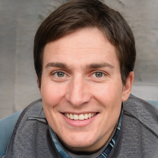 Joyful white young-adult male with short  brown hair and blue eyes