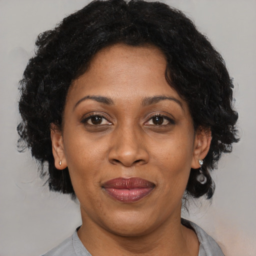 Joyful black adult female with short  brown hair and brown eyes