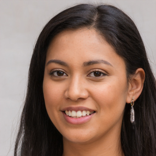 Joyful latino young-adult female with long  brown hair and brown eyes