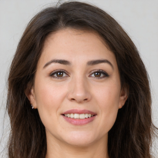 Joyful white young-adult female with long  brown hair and brown eyes