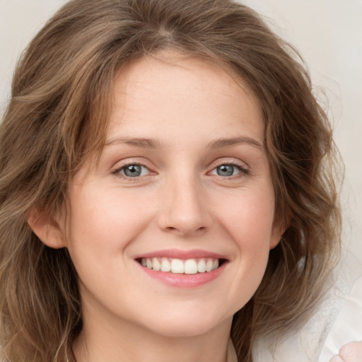 Joyful white young-adult female with medium  brown hair and green eyes