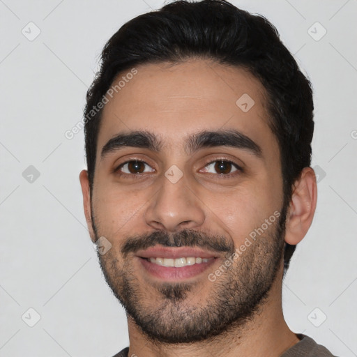 Joyful latino young-adult male with short  black hair and brown eyes