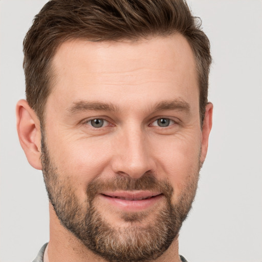 Joyful white adult male with short  brown hair and brown eyes