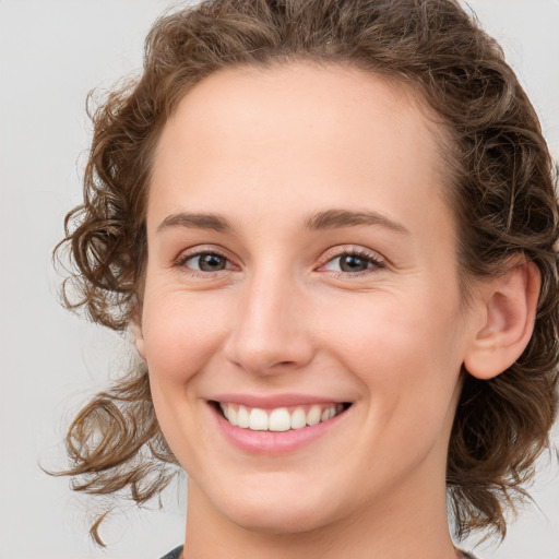 Joyful white young-adult female with medium  brown hair and green eyes