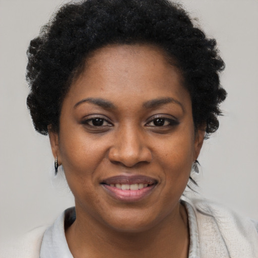 Joyful black young-adult female with short  black hair and brown eyes