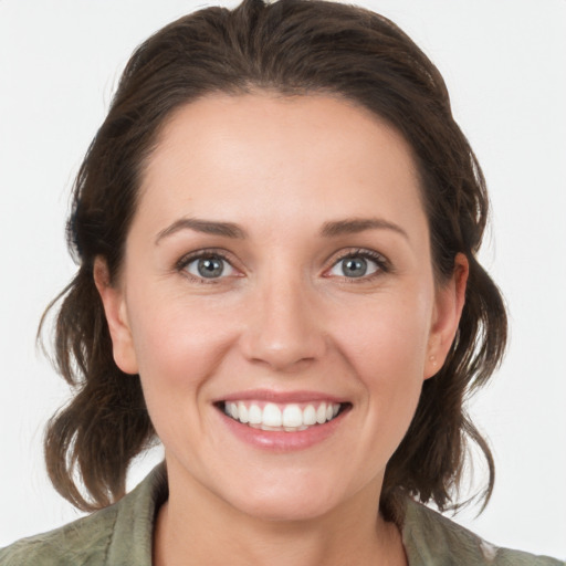 Joyful white young-adult female with medium  brown hair and grey eyes