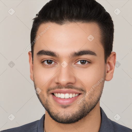 Joyful white young-adult male with short  black hair and brown eyes