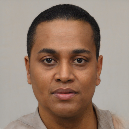 Joyful black young-adult male with short  black hair and brown eyes