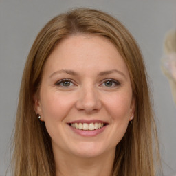 Joyful white young-adult female with long  brown hair and grey eyes