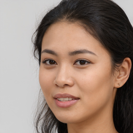 Joyful latino young-adult female with long  black hair and brown eyes