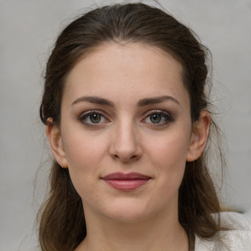 Joyful white young-adult female with medium  brown hair and grey eyes