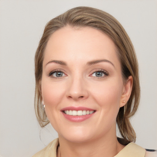 Joyful white young-adult female with medium  brown hair and blue eyes