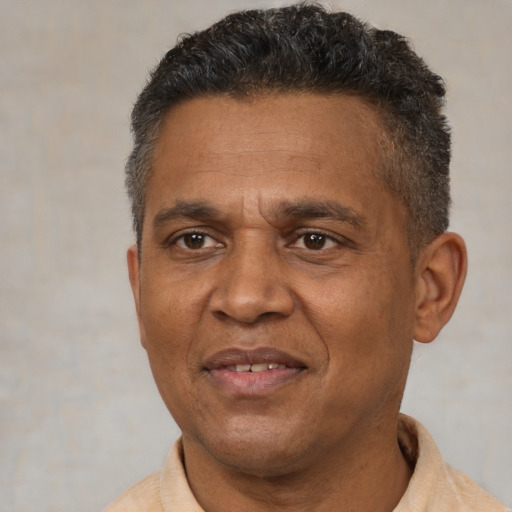 Joyful black adult male with short  brown hair and brown eyes