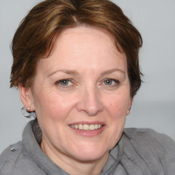 Joyful white adult female with medium  brown hair and blue eyes