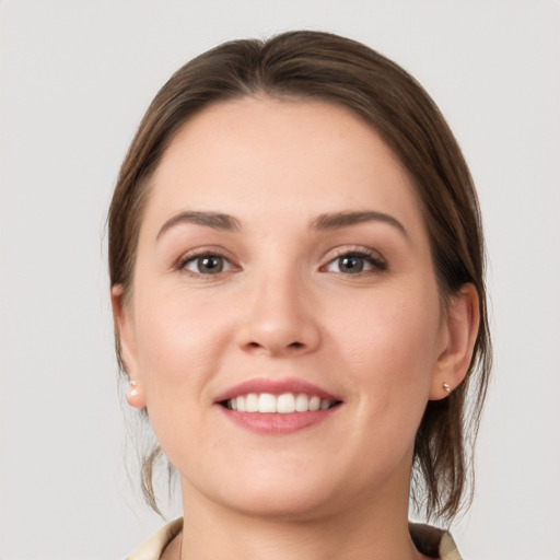 Joyful white young-adult female with medium  brown hair and grey eyes