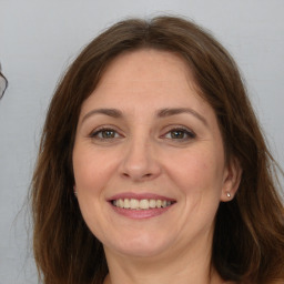 Joyful white adult female with long  brown hair and brown eyes