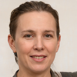 Joyful white adult female with medium  brown hair and grey eyes