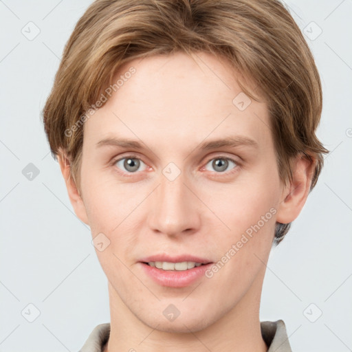 Joyful white young-adult male with short  brown hair and grey eyes