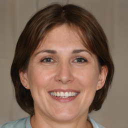 Joyful white adult female with medium  brown hair and brown eyes