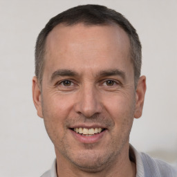 Joyful white adult male with short  brown hair and brown eyes