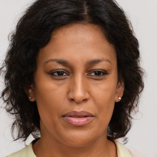 Joyful latino adult female with medium  brown hair and brown eyes