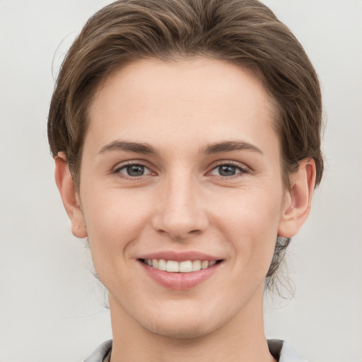 Joyful white young-adult female with short  brown hair and grey eyes