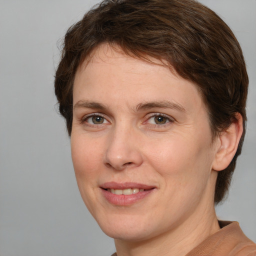 Joyful white adult female with medium  brown hair and green eyes