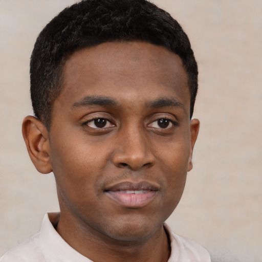 Joyful black young-adult male with short  brown hair and brown eyes