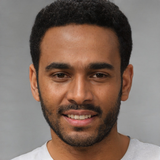 Joyful black young-adult male with short  black hair and brown eyes
