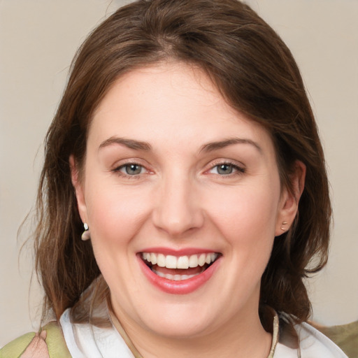 Joyful white young-adult female with medium  brown hair and green eyes